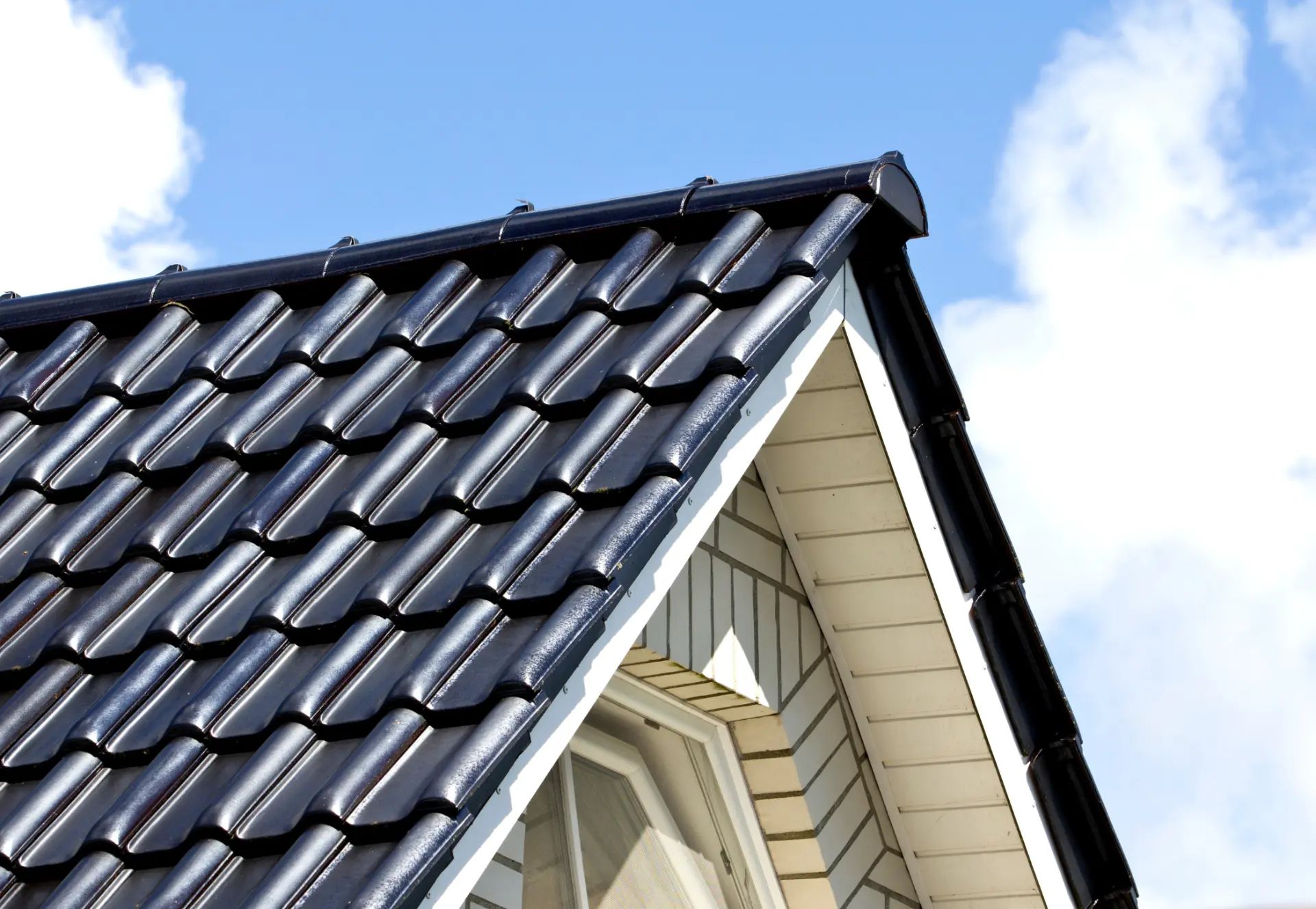 Plan macro de tuiles de toit métalliques grises montrant leur forme incurvée et leurs points de connexion